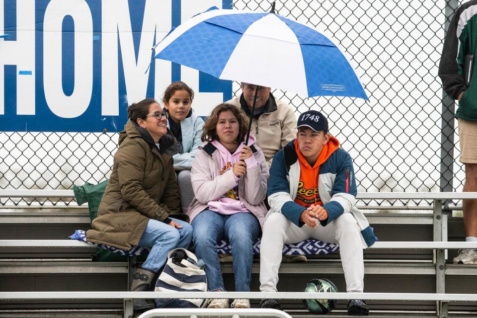 Fans share an umbrella to watch Wilmington Friends take on Howard at the Wilmington Friends football field in Alapocas, Saturday, Oct. 7, 2023. Howard won 50-21.