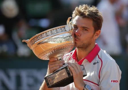 Stan Wawrinka of Switzerland kisses the trophy as he poses during the ceremony after winning the men's singles final match against Novak Djokovic of Serbia at the French Open tennis tournament at the Roland Garros stadium in Paris, France, June 7, 2015. REUTERS/Vincent Kessler