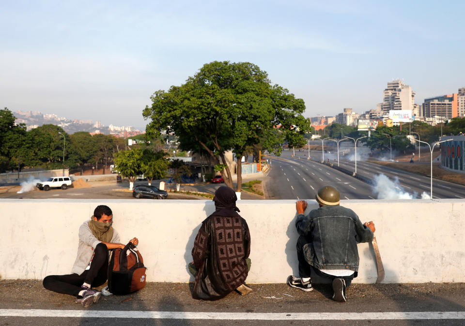 Opposition supporters take cover near the Generalisimo Francisco de Miranda Airbase "La Carlota", in Caracas, Venezuela April 30, 2019. (Photo: Carlos Garcia Rawlins/Reuters)