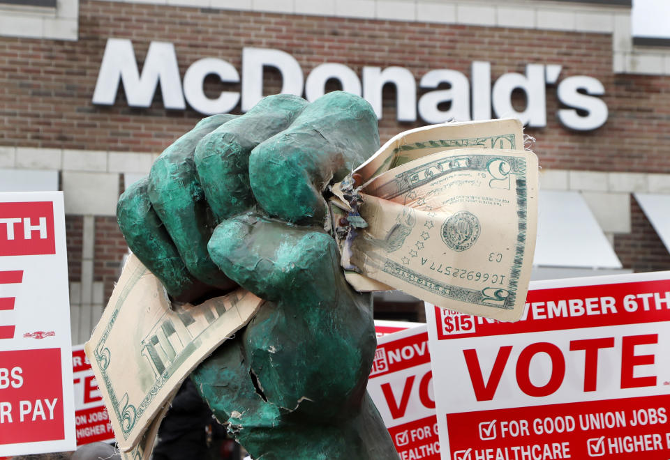 A protester holds up an oversize fist clenching fifteen dollars during a rally in front of a McDonald's restaurant Tuesday, Oct. 2, 2018, in Detroit. The group of protesters were calling for higher pay and the right to form unions in Michigan. (AP Photo/Carlos Osorio)