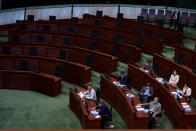 Pro-China lawmakers sitting against the empty seats of pro-democracy lawmakers as they attend the first and second reading of "Improving Electoral System (Consolidated Amendments) Bill 2021" at the Legislative Council in Hong Kong, Wednesday, April 14, 2021. Hong Kong’s electoral reform bill was introduced in the city’s legislature on Wednesday, setting in motion changes that will give Beijing greater control over the process while reducing the number of directly elected representatives. (AP Photo/Vincent Yu)