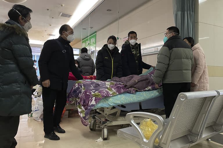 Un hombre cubre con un trapo el rostro de una mujer mayor cuyos signos vitales se estancaron mientras familiares emotivos se reúnen en silencio a su alrededor para despedirse por última vez antes de que se lleven su cuerpo al departamento de emergencias del Hospital Popular No. 4 de Langfang en la ciudad de Bazhou en Hebei, provincia del norte de China