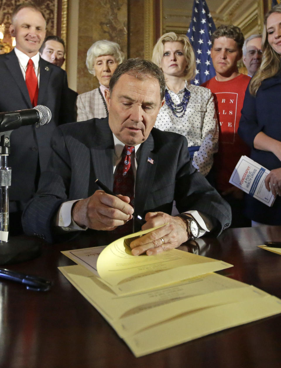 FILE - In this April 19, 2016, file photo, Utah Gov. Gary Herbert looks up during a ceremonial signing of a state resolution declaring pornography a public health crisis, at the Utah State Capitol, in Salt Lake City. More than a dozen states have moved to declare pornography a public health crisis, encouraging supporters but raising concerns among experts who say the label goes too far and carries its own risks. Arizona became the latest of 16th state to pass a resolution in at least one legislative chamber on Monday, May 6, 2019, calling for a systemic effort to prevent exposure to porn that's increasingly accessible to kids at younger ages online. (AP Photo/Rick Bowmer, File)