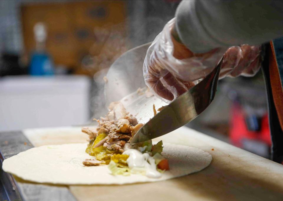 Ahmed Aldoori, an Iraqi immigrant and owner of the new Heisenberg Mediterranean food truck, prepares a meal on Friday, Nov. 12, 2021, at a location in Clive. Aldoori has been working with Catholic Charities and USCRI to provide hot meals to Afghan evacuees when they arrive to Des Moines. 