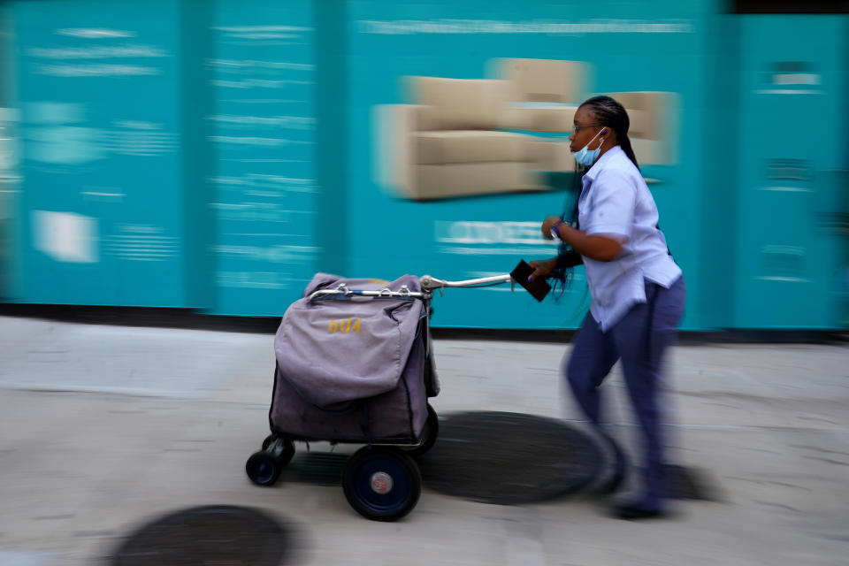 A United States Postal Service (USPS) worker delivers mail in the Manhattan borough of New York City, New York, U.S., August 17, 2020. REUTERS/Carlo Allegri