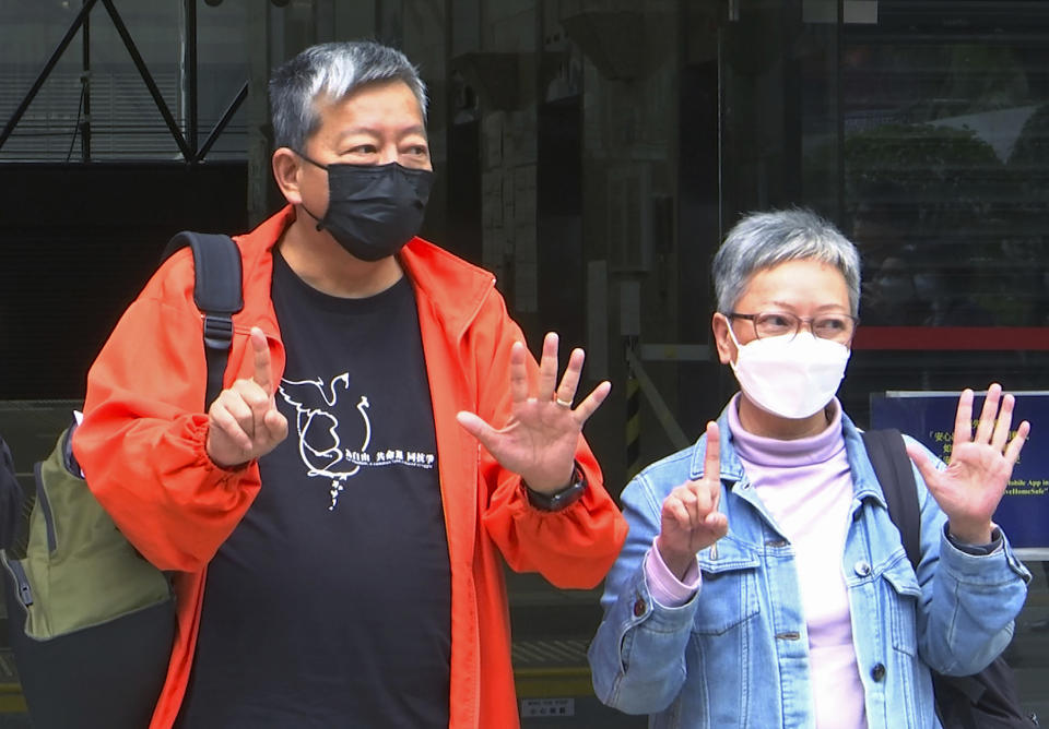 In this image made from video, pro-democracy activist Lee Cheuk-yan, left, and his supporter Cyd Ho, raise five fingers, signifying the "Five demands - not one less" after being released on bail at a court in Hong Kong, Wednesday, April 7, 2021. Three veteran Hong Kong pro-democracy activists, including well-known publisher Jimmy Lai, have pleaded guilty to taking party in an unauthorized rally that resulted in violence between police and participants, media reported Wednesday. (AP Photo/Rafael Wober)