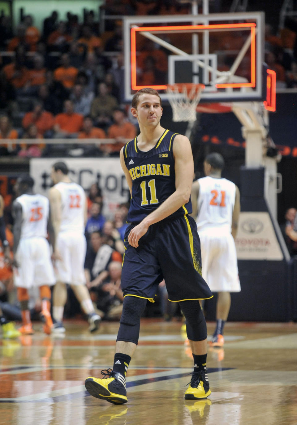 Michigan guard Nik Stauskas (11) looks over at Illinois fans after making a 3-point shot to end the first half of an NCAA college basketball game Tuesday, March 4, 2014, in Champaign, Ill. (AP Photo/Rick Danzl)