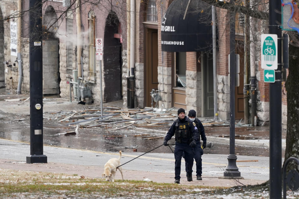 A K-9 team works in the area of an explosion in downtown Nashville, Tenn., Friday, Dec. 25, 2020. Buildings shook in the immediate area and beyond after a loud boom was heard early Christmas morning.(AP Photo/Mark Humphrey)