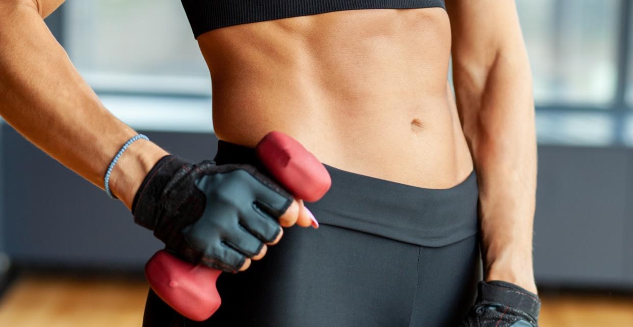  woman holding dumbbells for ab workout 