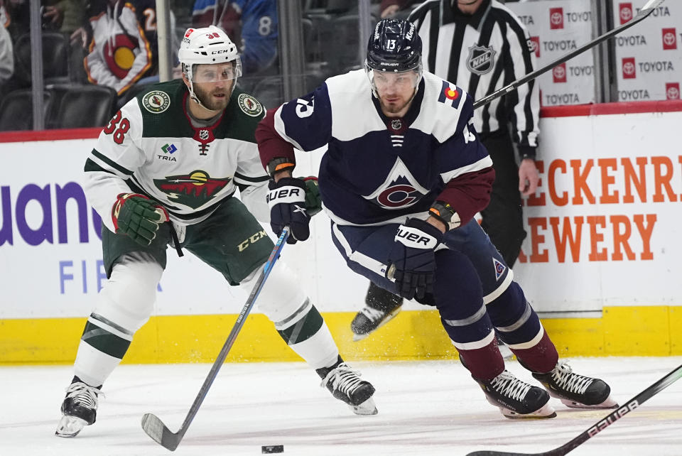 Colorado Avalanche right wing Valeri Nichushkin, right, collects the puck next to Minnesota Wild right wing Ryan Hartman during the first period of an NHL hockey game Friday, March 8, 2024, in Denver. (AP Photo/David Zalubowski)