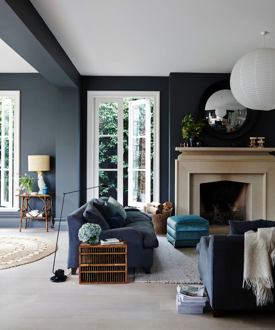 Open plan living room with grey walls and stone fireplace and white door