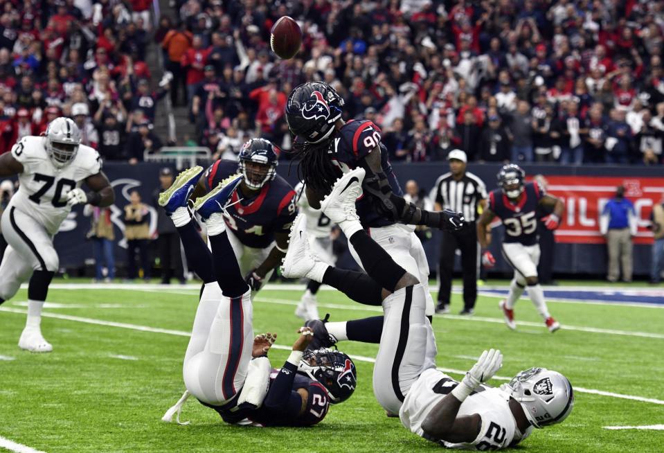 <p>Houston Texans defensive end Jadeveon Clowney (90) catches an interception during the first half of the AFC Wild Card playoff football game against the Oakland Raiders at NRG Stadium. Mandatory Credit: Jerome Miron-USA TODAY Sports </p>