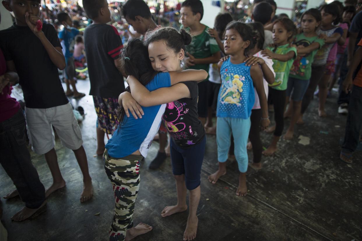 Honduran girls hug while waiting in line for a chance to play on the playground at a camp set up by a caravan of thousands of Central American migrants in Juchitan, Mexico, on Wednesday. (Photo: Rodrigo Abd/Associated Press)