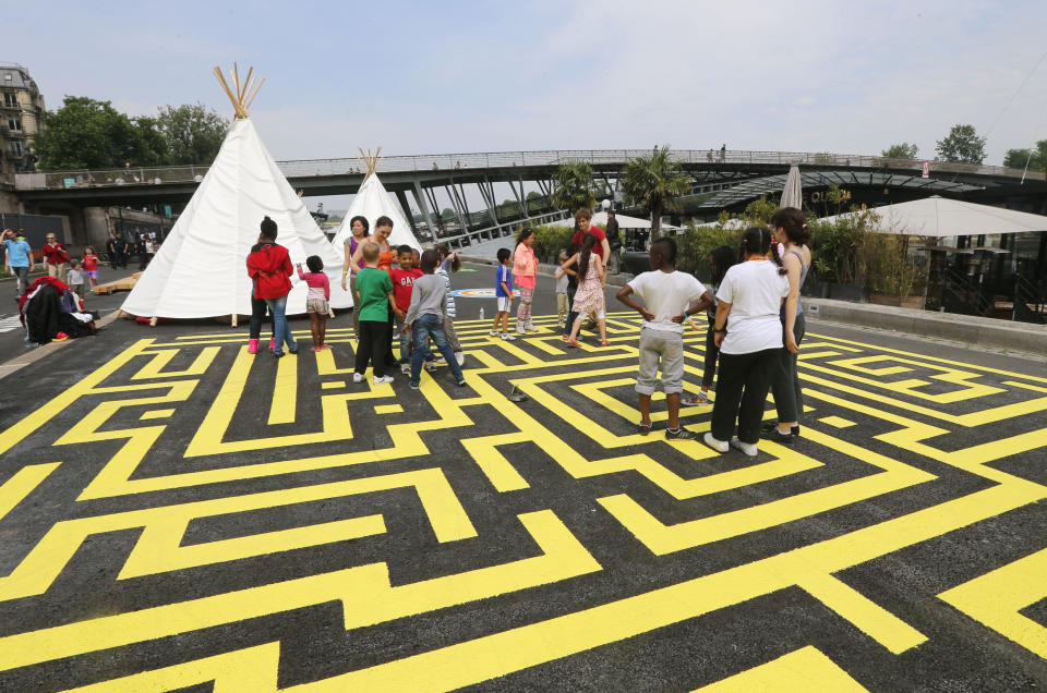 Children play on the renovated Left Bank of the Seine river where a new promenade has been inaugurated, Wednesday, June 19, 2013 in Paris. The 2.3 km (1.4 miles) walkway offers gardens, cafes, culture and sports activities. (AP Photo/Jacques Brinon)