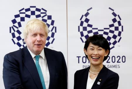 Britain's Foreign Secretary Boris Johnson smiles with Japan's Minister in charge of overseeing preparations for Tokyo's 2020 Summer Olympic Games Tamayo Marukawa in front of Tokyo 2020 Olympics and Paralympics emblems during their meeting in Tokyo, Japan July 21, 2017. REUTERS/Issei Kato