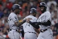 Chicago White Sox's Tim Anderson and Luis Robert Jr. celebrate after scoring on a double by Andrew Vaughn during the ninth inning of the team's baseball game against the Houston Astros, Thursday, March 30, 2023, in Houston. (AP Photo/Kevin M. Cox)