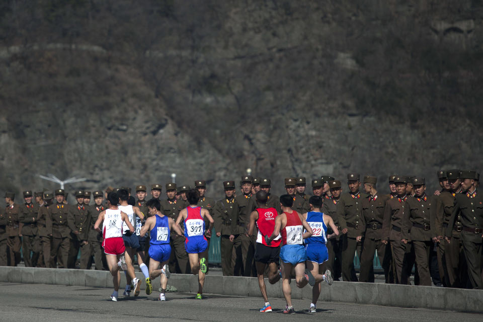 FILE - In this April 14, 2013 file photo, marathon runners pass by a long row of North Korean soldiers as they cross a bridge in Pyongyang as North Korea hosts the 26th Mangyongdae Prize Marathon to mark the birthday of the late leader Kim Il Sung on April 15. For the first time ever, North Korea is opening up the streets of its capital to runner-tourists for the annual Pyongyang marathon, undoubtedly one of the most exotic feathers in any runner’s cap. Tourism companies say they have been inundated by requests to sign up for the April 13, 2014 event, which this year will include amateur runners from around the world. (AP Photo/David Guttenfelder, File)