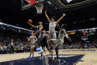 Providence guard Jared Bynum, center left, shoots against Xavier's Cesare Edwards (4) during the second half of an NCAA college basketball game, Wednesday, Feb. 1, 2023, in Cincinnati. (AP Photo/Jeff Dean)