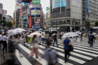 Morning commuters with umbrella cover a crosswalk Tuesday, July 27, 2021, in Tokyo. The rains have come to Tokyo and its Olympics. After many days of blistering sunshine, the rain cooled Tokyo by about 10 degrees and took the edge off. But worries about the effect of Tropical Storm Nepartak have led to changes in events and some cancellations of practices as preparations proceed. The storm is expected to make landfall in Japan on Tuesday evening. (AP Photo/Kiichiro Sato)