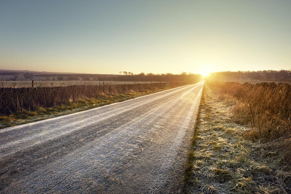 Road with sunrise at the end on a frosty morning