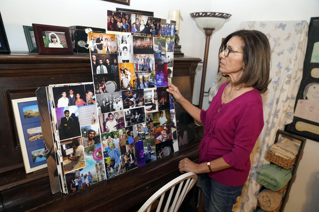 Dolores Cruz looks at a college of pictures of her youngest son, Eric Cruz, and some of his bandmates on Wednesday, Feb. 1, 2023, at her home in San Gabriel, Calif. Cruz published an essay in 2022 about grieving for her son, who died in a car crash in 2017. "Died Suddenly" used a screenshot of the headline in the film, portraying his death as vaccine related. (AP Photo/Marcio Jose Sanchez)