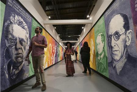 People view a series of paintings titled "Pay for Your Pleasure" during an exhibition of work by the late artist Mike Kelley during a media preview at The Geffen Contemporary at The Museum of Contemporary Art in Los Angeles, California March 28, 2014. REUTERS/Jonathan Alcorn
