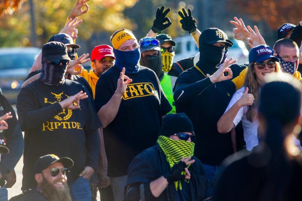 Proud Boys and demonstrators flash hand gestures that the Southern Poverty Law Center describes as an attempt to “troll liberals” during a downtown Raleigh rally in support of President Donald Trump Saturday, Nov. 28, 2020.