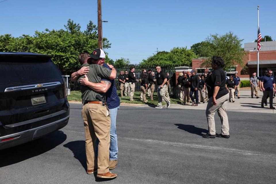Officers embrace before the law enforcement processional for Investigator William “Alden” Elliott, with the NC Department of Adult Corrections, leaves the Mecklenburg County Medical Examiner’s Office from Charlotte to Newton on Thursday, May 2, 2024.