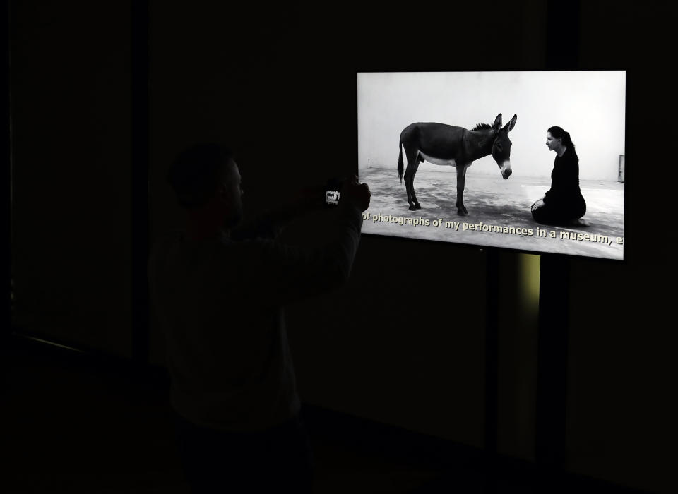 A visitor takes a photo during a press visit of the art exhibition "Marina Abramovic - The Cleaner" in the Museum of Contemporary Art in Belgrade, Serbia, Saturday, Sept. 21, 2019. Abramovic is displaying her work in her native Belgrade for the first time in 44 years and she says that returning home has been highly emotional. (AP Photo/Darko Vojinovic)