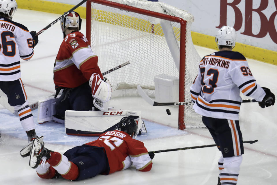 The puck gets past Florida Panthers goaltender Sam Montembeault, left, for a goal by Edmonton Oilers center Leon Draisaitl (not shown) during the third period of an NHL hockey game, Saturday, Feb. 15, 2020, in Sunrise, Fla. (AP Photo/Lynne Sladky)