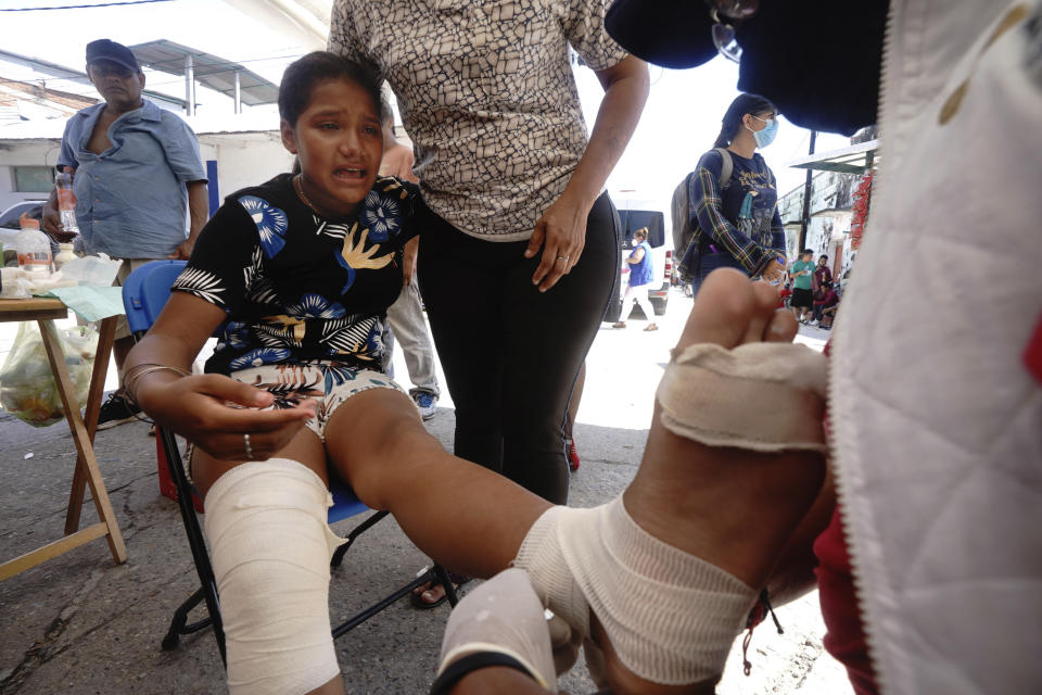 A volunteer providing first aide, wraps the foot of a migrant who is part of a caravan taking a day of rest before continuing their trek across southern Mexico to the U.S. border, in Huixtla, Chiapas state, Mexico, Tuesday, Oct. 26, 2021. (AP Photo/Marco Ugarte)