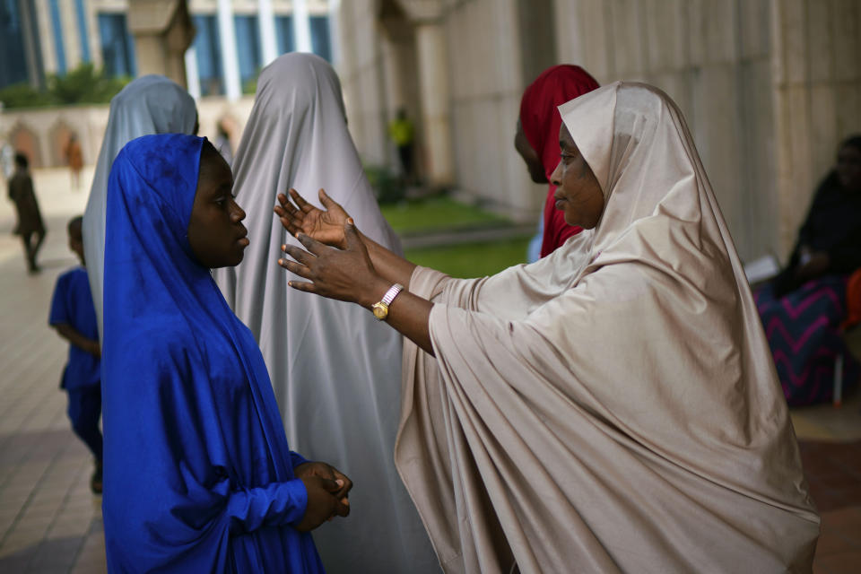 A Nigerian woman attends Friday prayers at the central mosque is security checked a day prior to the election, in Abuja, Nigeria, Friday Feb. 15, 2019. Nigeria surged into the final day of campaigning ahead of Saturday's election, as President Muhammadu Buhari made one last pitch to stay in office while top challenger Atiku Abubakar shouted to supporters: "Oh my God! Let them go! Let them go!" (AP Photo/Jerome Delay)