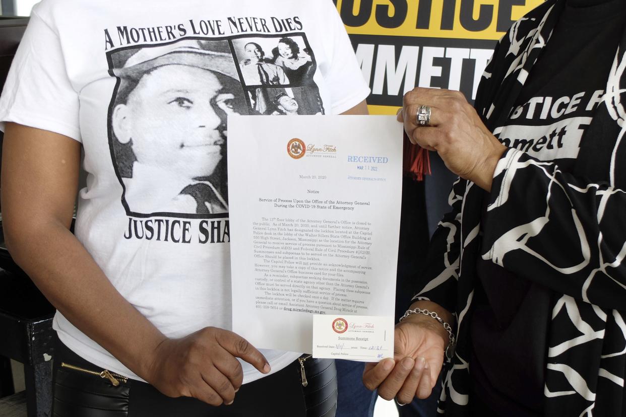 Deborah Watts, right, and Priscilla Sterling, cousins of Emmett Till, show a document used by Mississippi Attorney General Office representative Wayne Lynch, to indicate receipt of a poster and accompanying thumb drive that allegedly has almost 300,000 signatures on a petition seeking a renewed probe of the 1955 lynching.