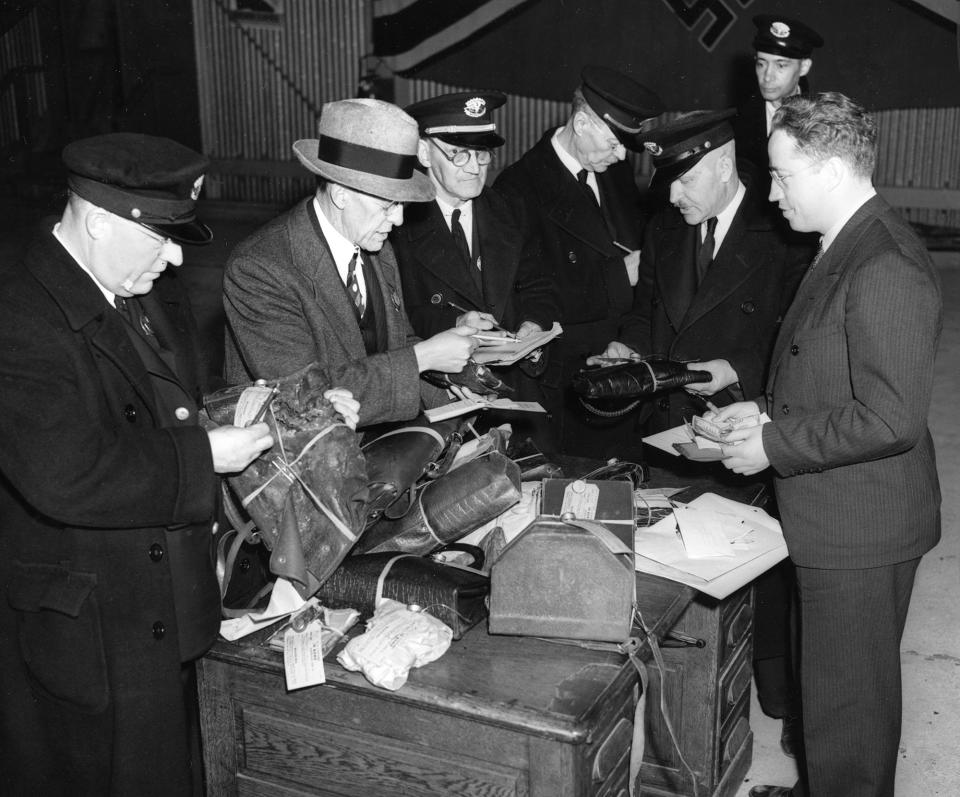 <p>Customs officers search through baggage items salvaged in the Hindenburg explosion in Lakehurst, N.J., May 6, 1937. (AP Photo) </p>