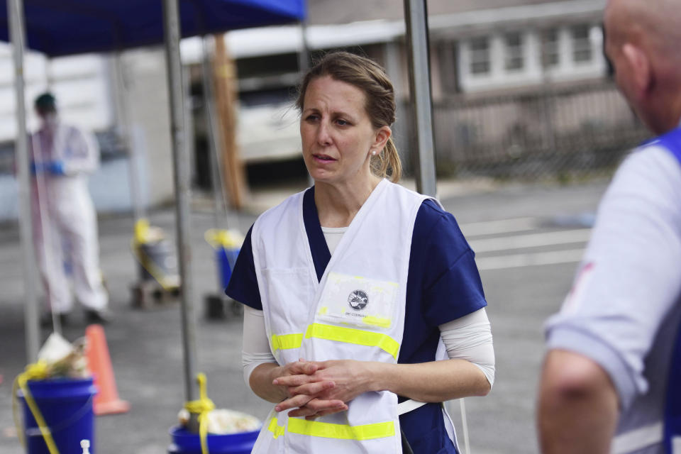 Dr. Anita Stewart speaks with clinical care providers during drive-thru testing by the Fayette County Health Department in Oak Hill, W.V. on Thursday, March 19, 2020. (Chris Jackson/The Register-Herald via AP)