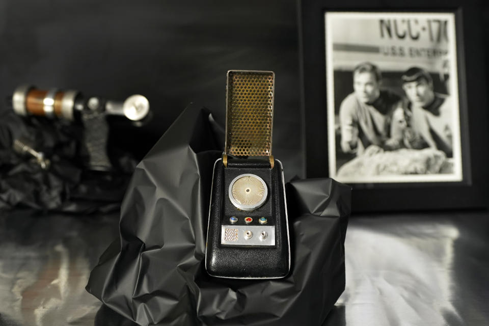 A prop called a Starfleet communicator, center, sits on display at Heritage Auctions, amongst others items from the 1960's television series, Thursday, Aug. 30, 2023, in Irving, Texas. While Greg Jein's work over nearly half a century making miniature models in Hollywood included such iconic creations as the alien mothership in "Close Encounters of the Third Kind," he was also a lifelong collector of costumes, props, scripts, artwork and photographs from the shows he loved, including countless rare items from the "Star Trek" and "Star Wars" franchises. Thousands of those items, including those Jein collected and those he created, will be offered up by Heritage Auctions next month in Dallas. (AP Photo/Tony Gutierrez)
