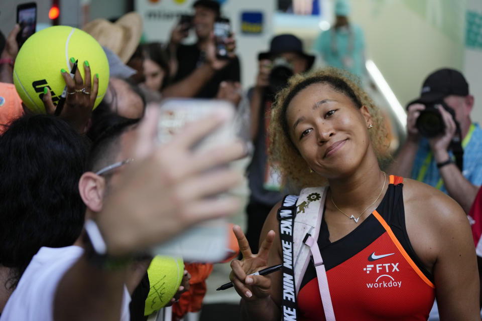 Naomi Osaka of Japan poses for selfies with fans after winning her women's semifinal match against Belinda Bencic of Switzerland, at the Miami Open tennis tournament, Thursday, March 31, 2022, in Miami Gardens, Fla. (AP Photo/Rebecca Blackwell)