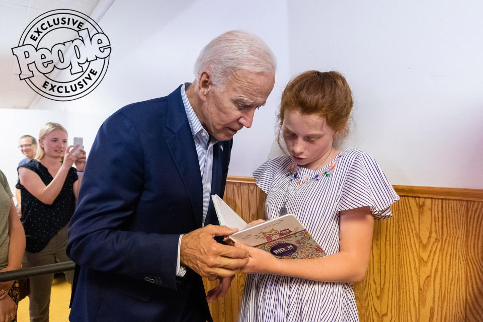 A young girl shares her favorite book with Biden after a community event at the Mississippi Valley Fairgrounds in Davenport, Iowa, on June 11, 2019.