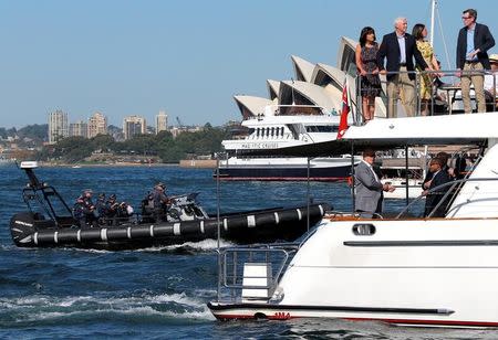 Armed Australian police can be seen near the boat where U.S. Vice President Mike Pence stands with his wife Karen and officials in front of the Sydney Opera House on Sydney Harbour, Australia, April 23, 2017. REUTERS/Jason Reed
