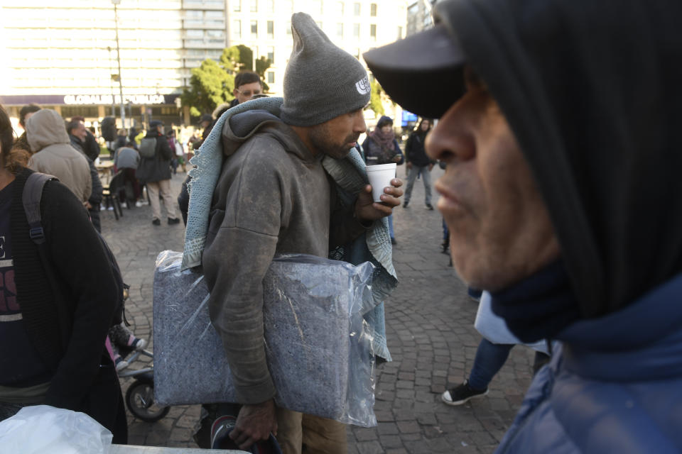 People eat a free breakfast served by a soup kitchen that was set up at the Obelisk as a protest against the city government's "hygiene and cleanliness" policy in Buenos Aires, Argentina, Tuesday, May 14, 2024. The policy involves authorities removing the homeless from the streets. (AP Photo/Gustavo Garello)