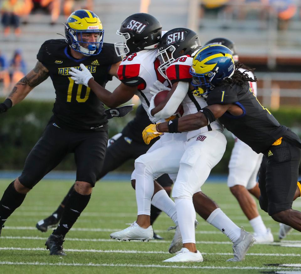 Delaware's Anthony Toro (left) and Kedrick Whitehead move against St. Francis ball carrier Lovell Armstead in the second quarter at Delaware Stadium Saturday, Sept. 11, 2021.