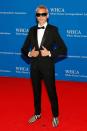 <p>adds a cool spin to his classic black tuxedo via striped dress shoes and thick-rimmed sunglasses. </p>