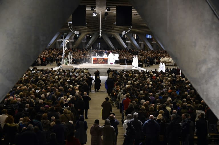 Pilgrims take part in a mass to celebrate the 158th anniversary of the virgin Mary's apparition to Bernadette Soubirous on February 11, 2016 inside the Pie X basilica of Lourdes, southern France