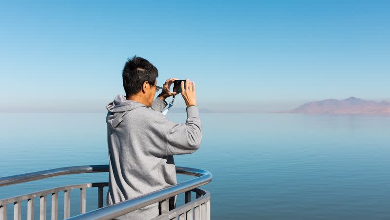 A tourist takes a photo from an overlook at Great Salt Lake State Park in Magna on Friday, Oct. 6, 2023.