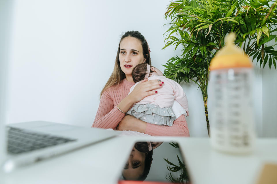Woman feeding the baby working from home