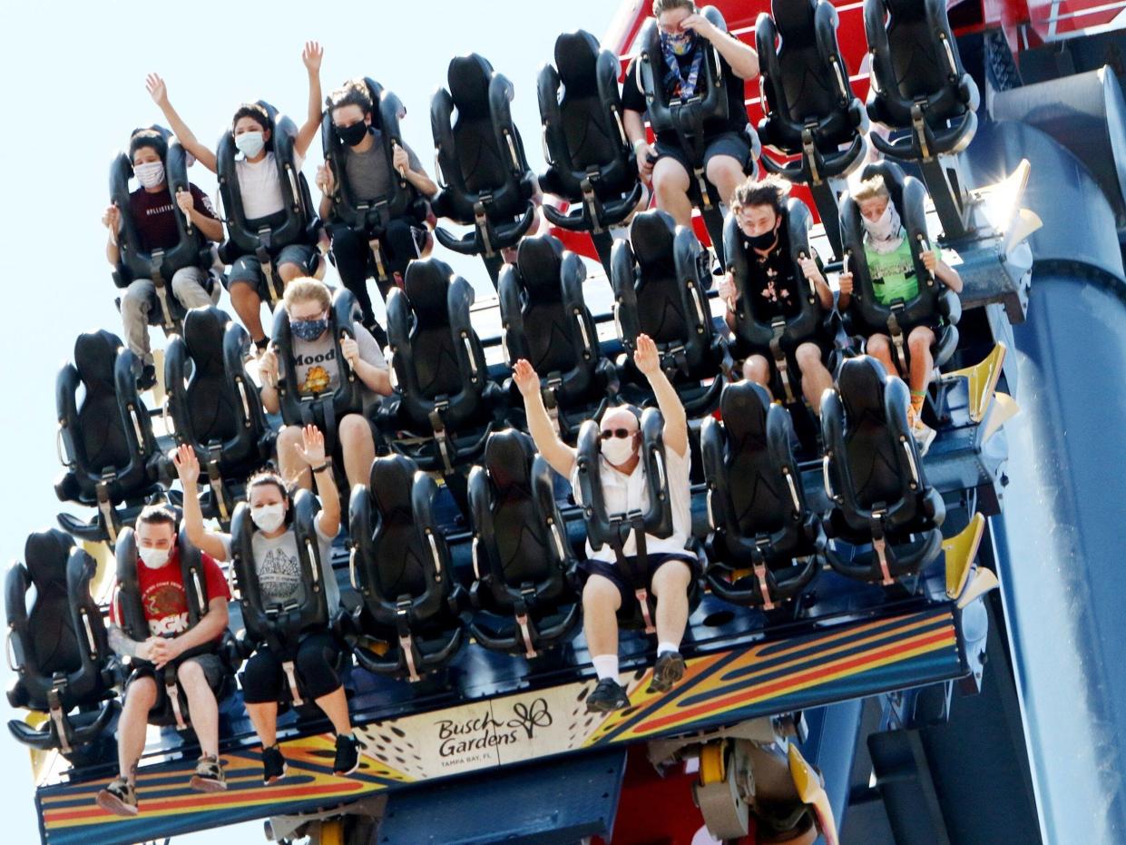 Patrons of Busch Gardens Tampa Bay enjoy the 200-foot dive on the SheiKra roller coaster, Thursday, June 11, 2020, in Tampa. The park, owned and operated by SeaWorld Entertainment, has reopened to the public for the first time in almost 3 months after closing on March 16 because of the coronavirus pandemic. (Douglas R. Clifford/Tampa Bay Times via AP)