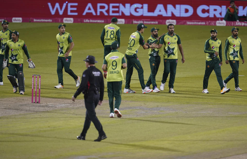 Pakistan's Wahab Riaz, third right, and teammates celebrate the dismissal of England's Moeen Ali during the third Twenty20 cricket match between England and Pakistan, at Old Trafford in Manchester, England, Tuesday, Sept. 1, 2020. (AP Photo/Jon Super, Pool)