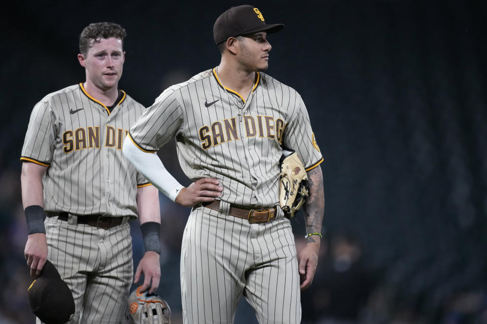San Diego Padres third baseman Manny Machado, front, and second baseman Jake Cronenworth wait for relief pitcher Nabil Crismatt to take the mound in the eighth inning of the team's baseball game against the Colorado Rockies on Tuesday, June 15, 2021, in Denver. (AP Photo/David Zalubowski)
