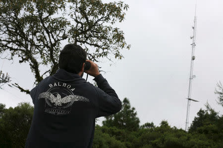 Peter Bloom, founder of non-profit group Rhizomatica, uses a pair of binoculars to observe an antenna of the community-run phone network in Santa Maria Yaviche, in Oaxaca state, Mexico, September 26, 2016. Picture taken September 26, 2016. REUTERS/Jorge Luis Plata