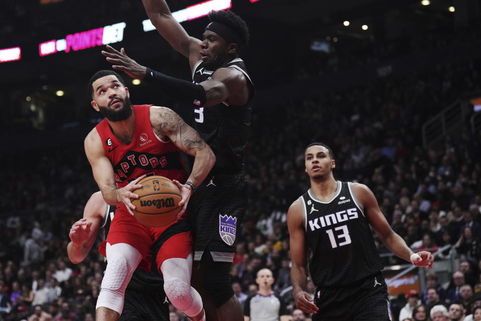 Toronto Raptors guard Fred VanVleet (23) tries to get around Sacramento Kings guard Terence Davis (3) as forward Keegan Murray (13) looks on during the first half of an NBA basketball game in Toronto on Wednesday, Dec. 14, 2022. (Nathan Denette/The Canadian Press via AP)